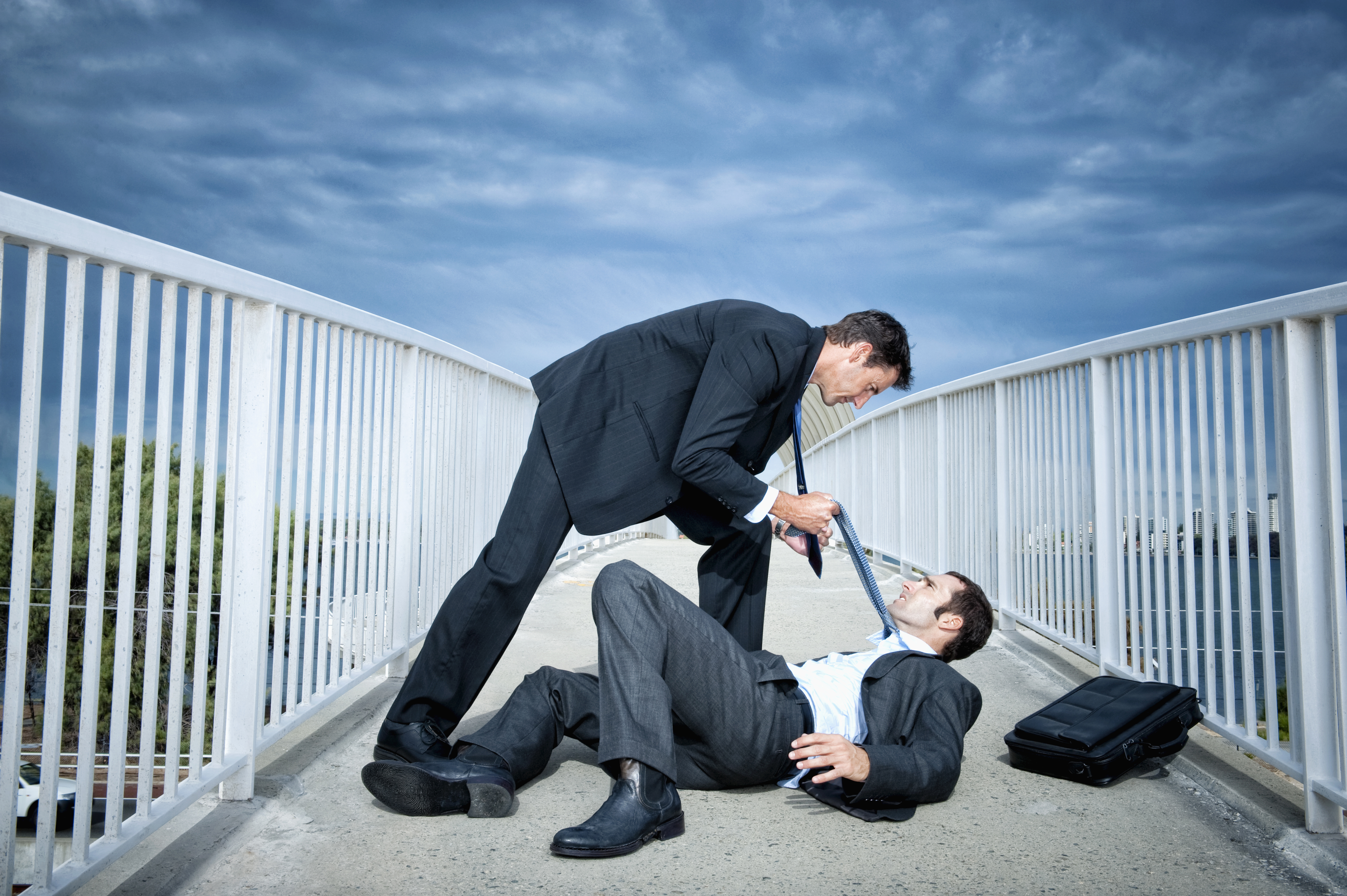 Caucasian businessmen fighting on elevated walkway