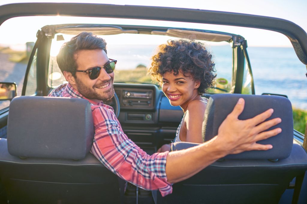 Young couple sitting in their car during roadtrip