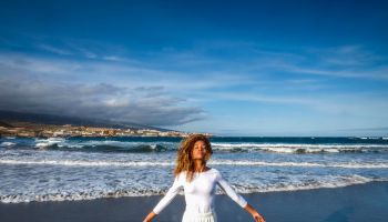 Spain, Tenerife, woman with closed eyes standing on the beach