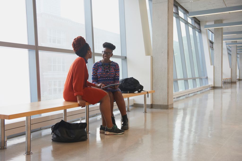 Women using digital tablet in hallway