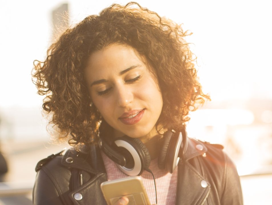 Beautiful young woman texting on her smart phone.