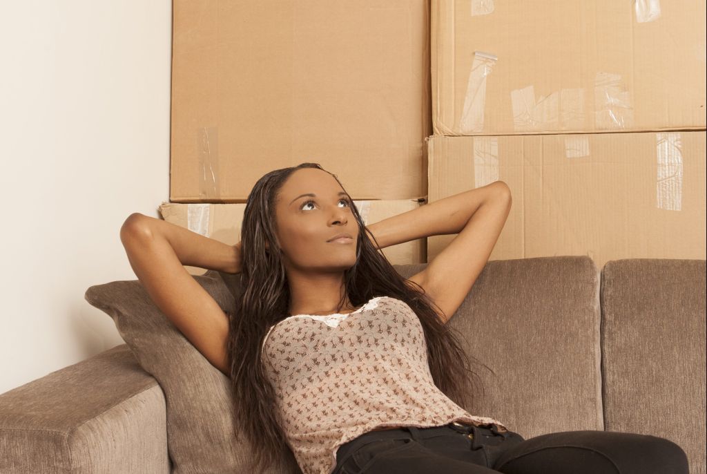 Woman sitting in flat surrounded by boxes