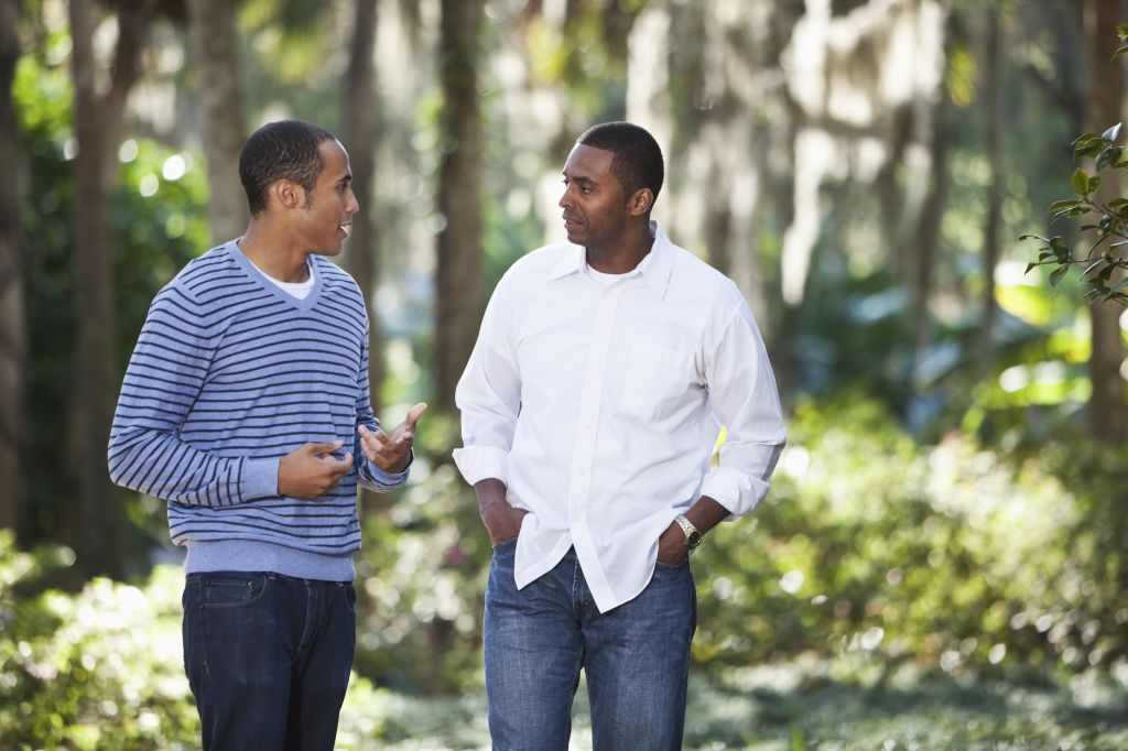 Young man talking with father in park