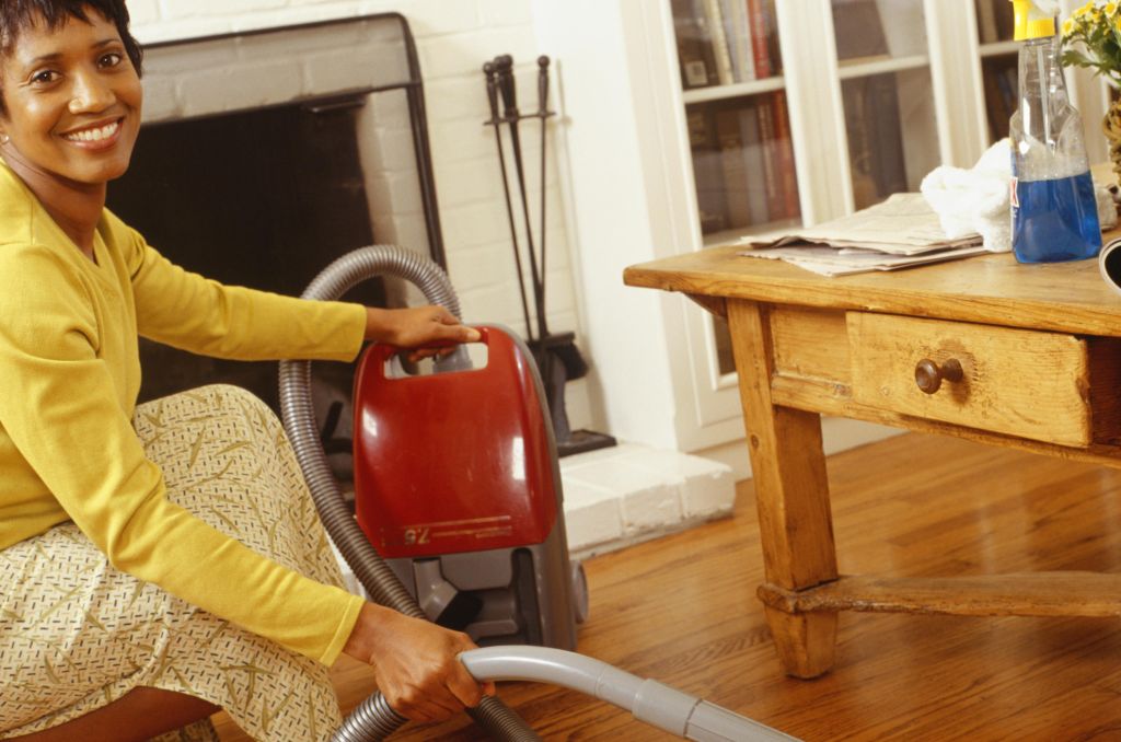 Woman vacuuming living room floor, portrait