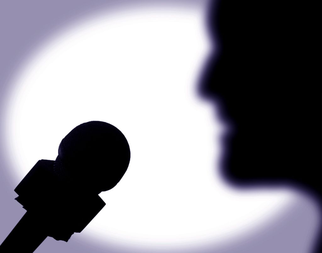 A person speaks into a microphone, 30 May 2001. Note: This image has been digit