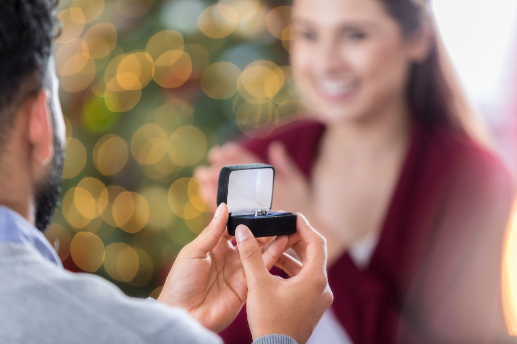 Closeup of ring box as young man proposes to girlfriend