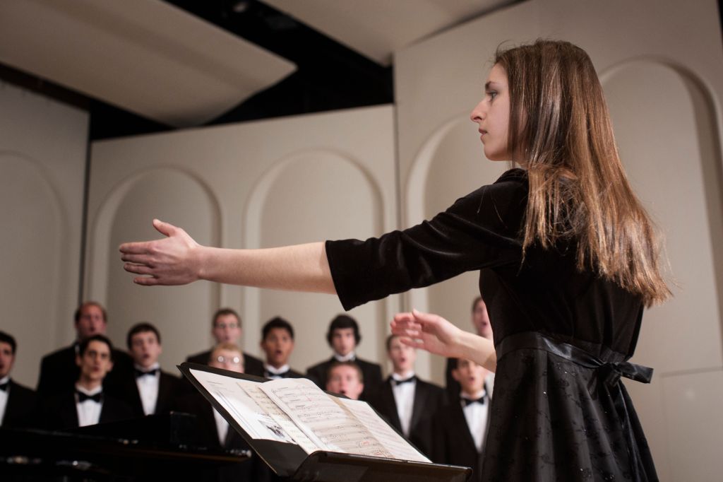 Conductor leading choir on stage