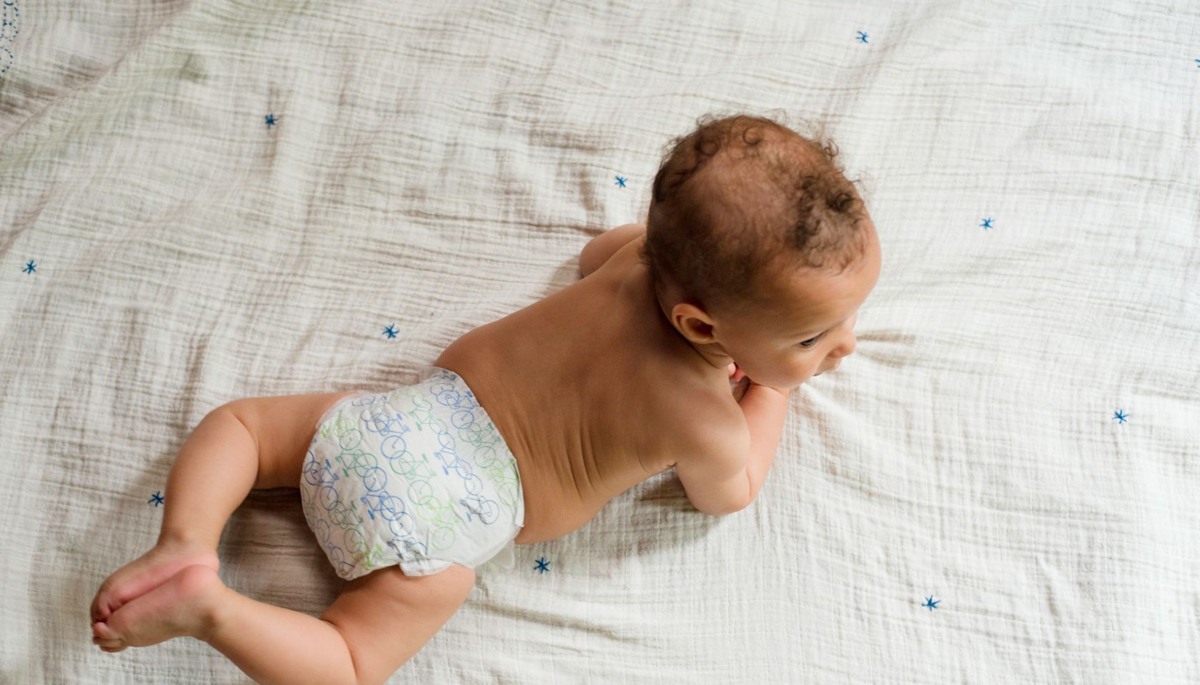 Baby boy lying on stomach, overhead view