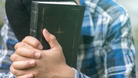 Human hand placed on the Bible, pray to God.
