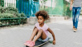 Girl playing with skateboard outdoors