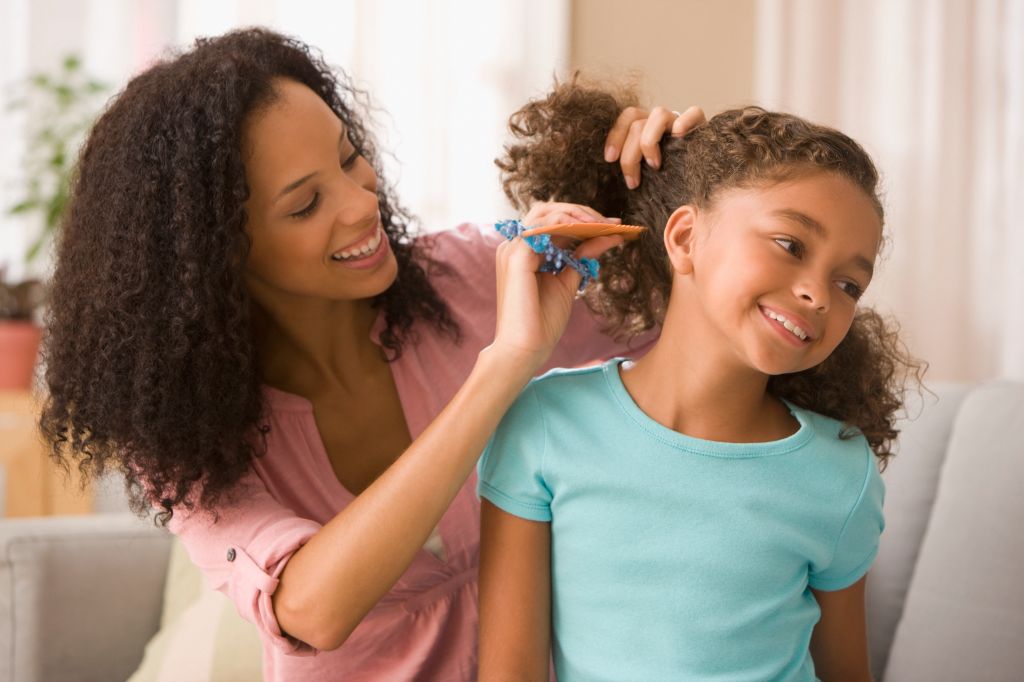 Mixed race mother brushing daughter's hair
