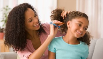 Mixed race mother brushing daughter's hair