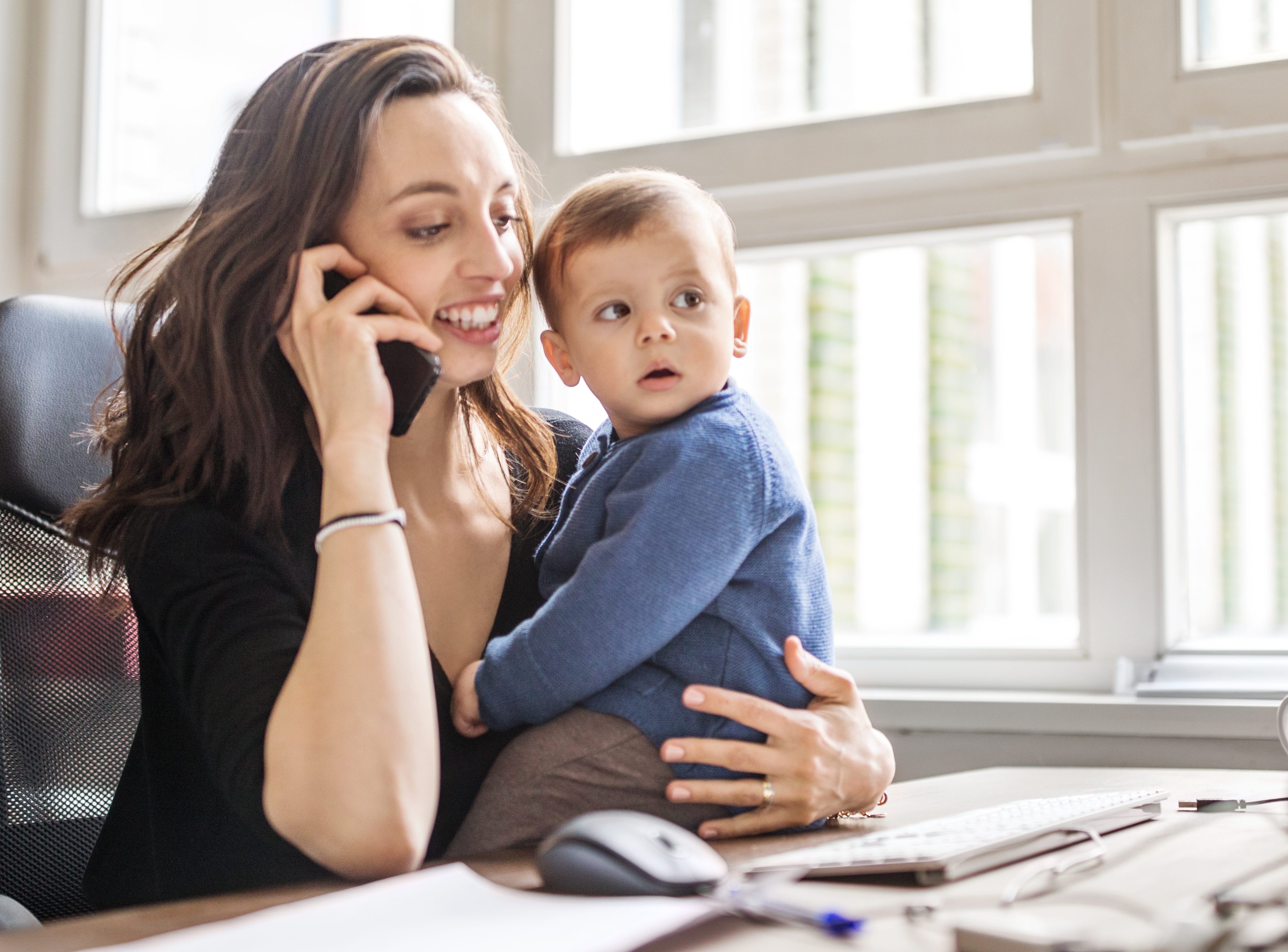 Single mother with son working in office