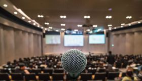 Business meeting concept, Microphone over the Abstract blurred photo of conference hall background