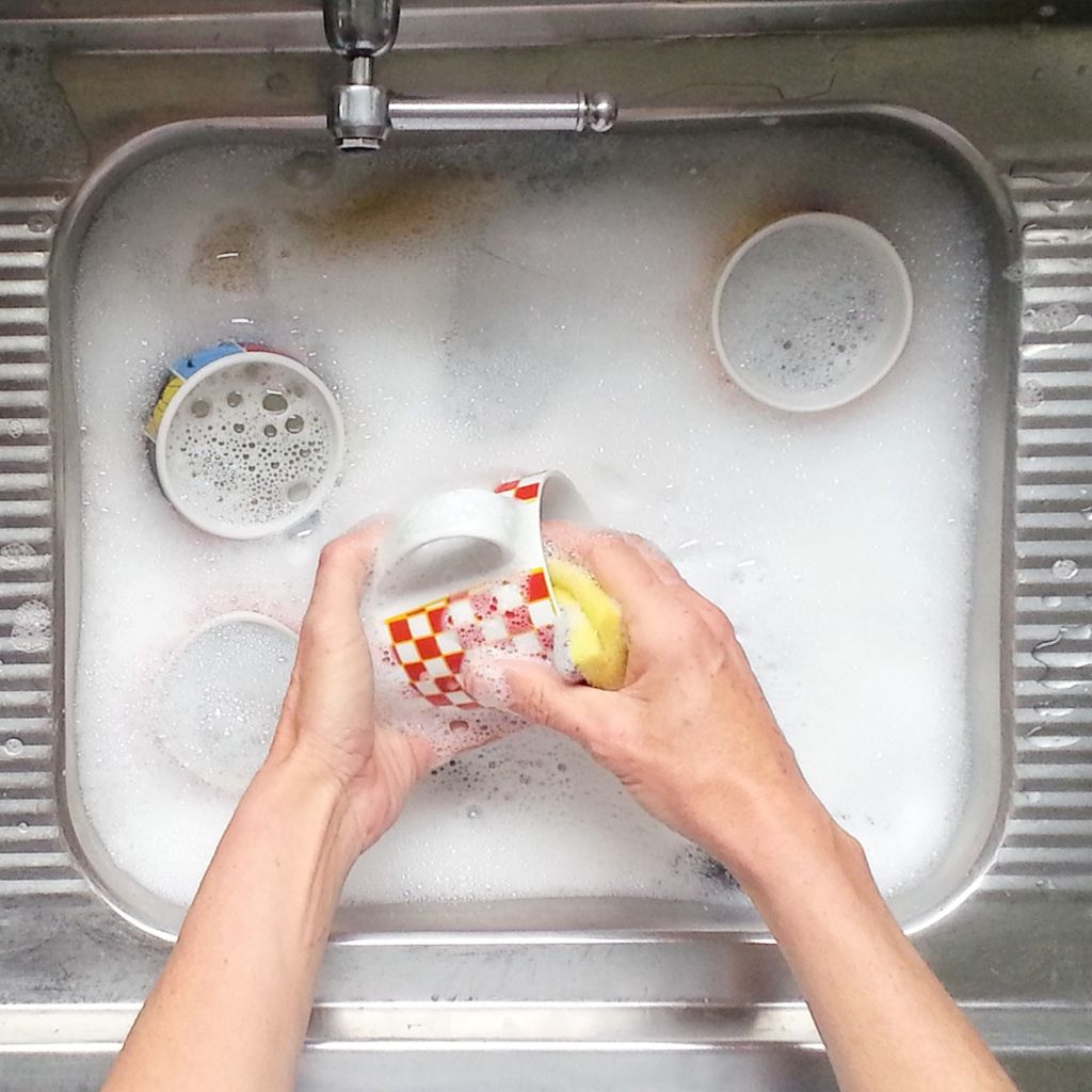 Cropped Image Of Hands Washing Cups In Sink