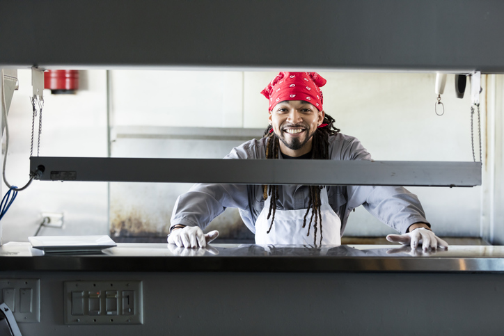 Mixed race man with dreadlocks in commercial kitchen