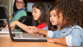 Elementary-age children learn computer coding in school.