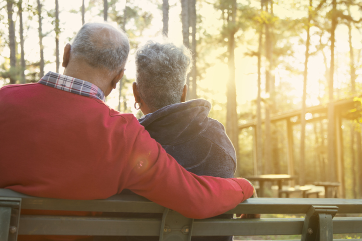 Active senior adult couple enjoy outdoor park at sunset.