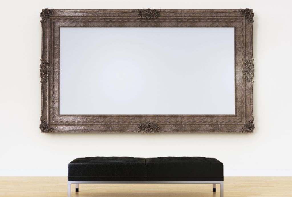 Empty picture frame above bench in art gallery