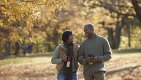 Black couple walking together in park in autumn
