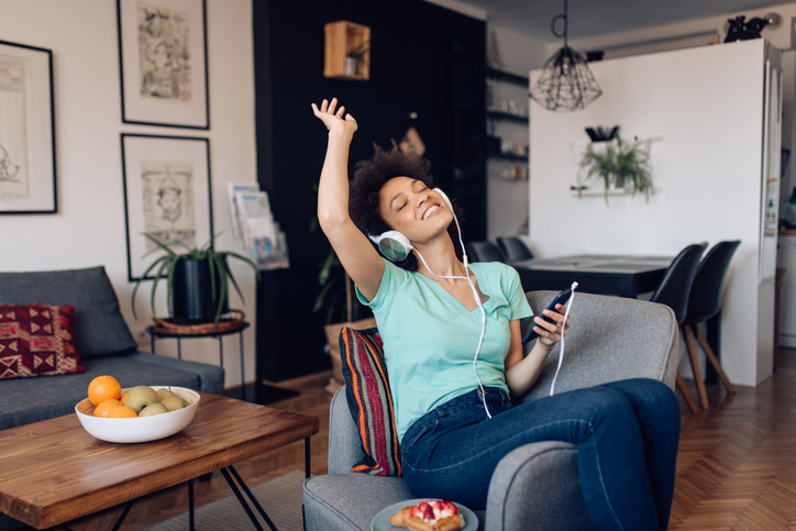 Beautiful Afro woman enjoying her favorite music at home