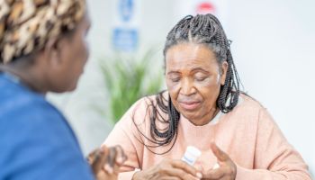 Elderly woman discussing treatment with nurse