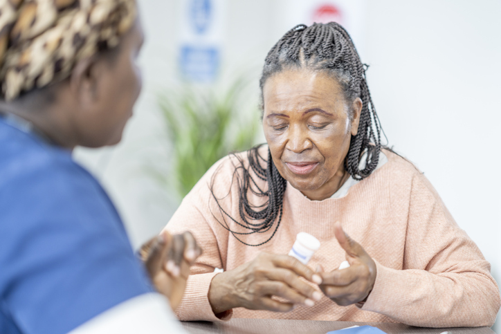 Elderly woman discussing treatment with nurse