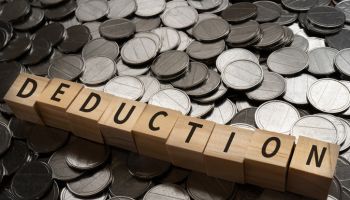 Wooden blocks with "DEDUCTION" text of concept and coins.
