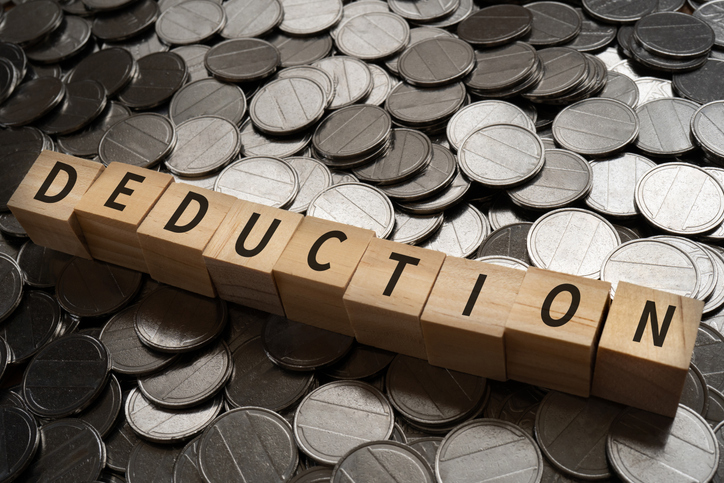 Wooden blocks with "DEDUCTION" text of concept and coins.