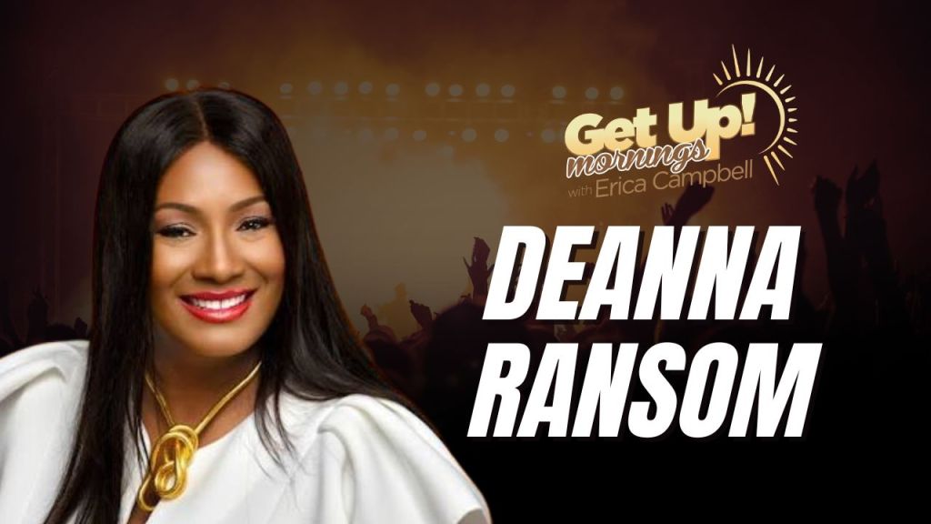 A smiling woman with long dark hair wearing a white outfit and gold jewelry, with the text "Get Up! mornings with Erica Campbell" and "DEANNA RANSOM" displayed.